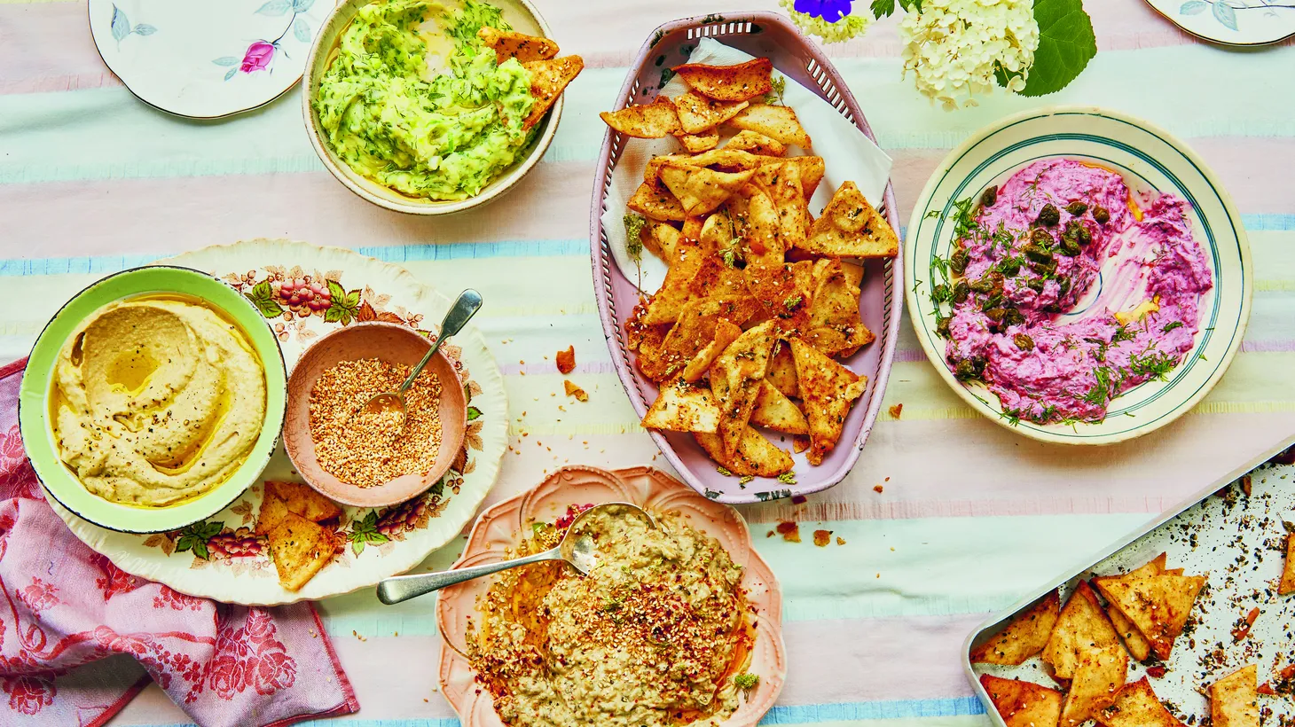 Herby skordalia, everything pita chips, and beetroot and dill tzatziki with fried capers make for a Greek-inspired tablescape.