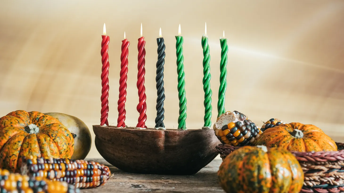 A kinara, a seven-branched candlestick, corn, fruits, and other vegetables are symbolic in a Kwanzaa celebration.