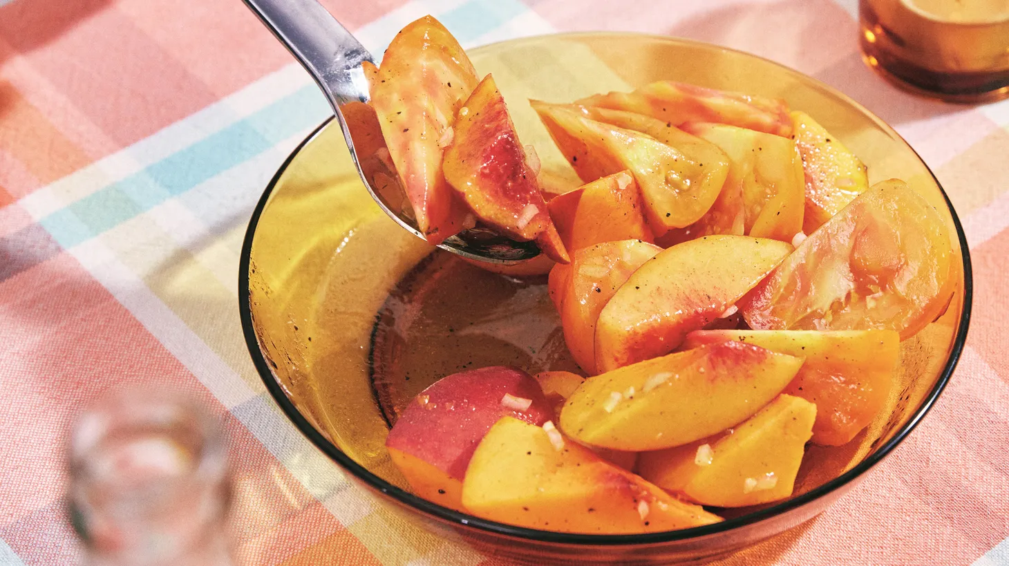 A tomato and stone fruit salad celebrates the sweetness of summer and gets a hint of bitterness from orange marmalade, turmeric, and a shallot vinaigrette.