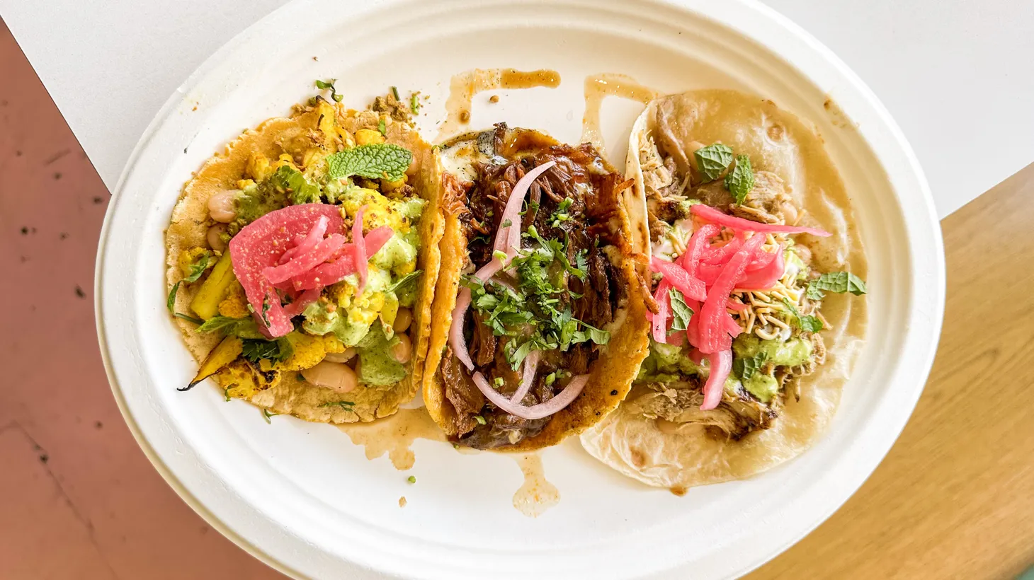 A mixed plate of birria, jeera chicken, and turmeric-laced cauliflower tacos is the perfect taste of everything at the Goat Mafia/Saucy Chick collaboration in Beverly Grove.