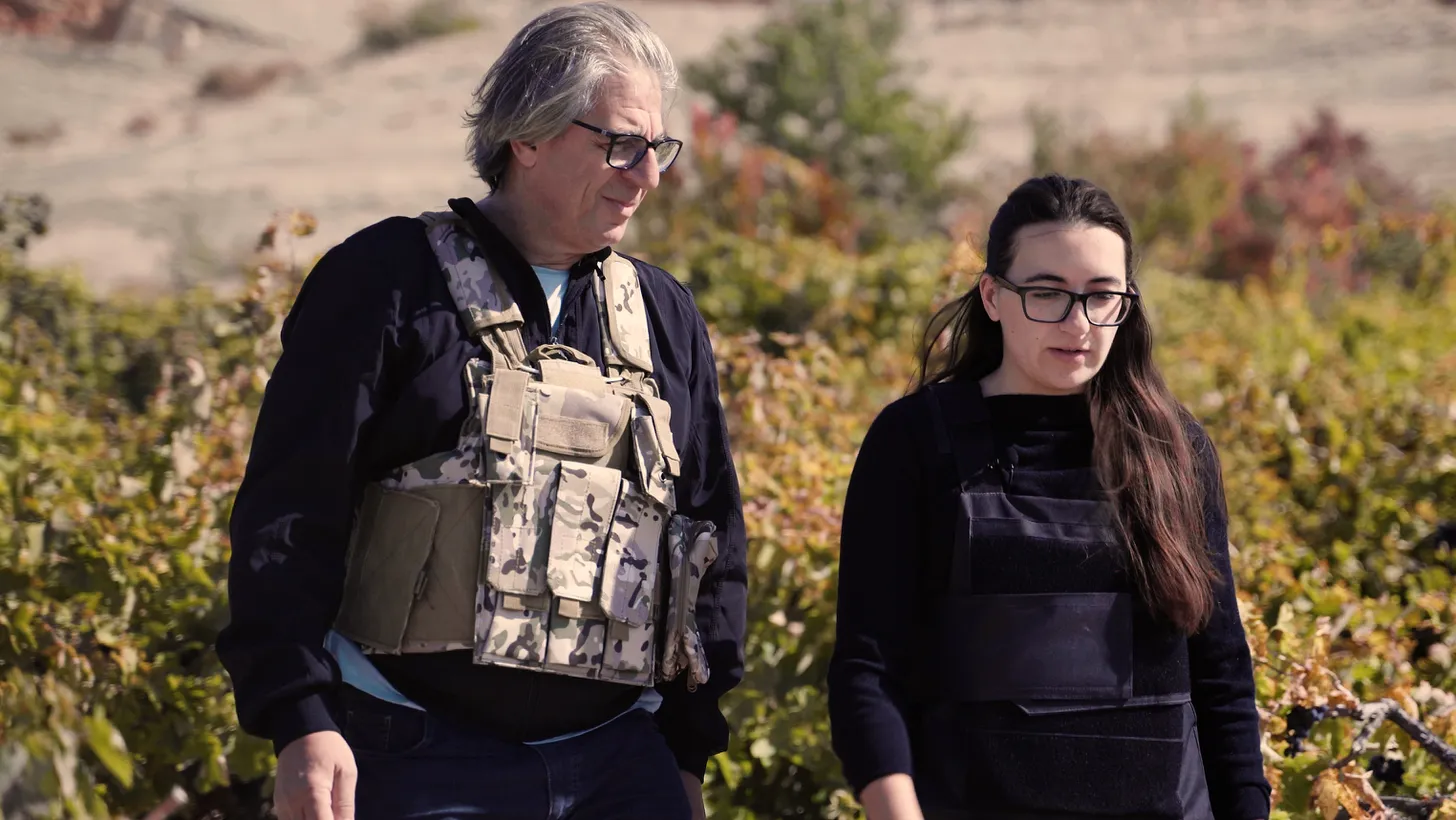 Vahe Keushguerian (left) and his daughter, Aimee, wear bullet-proof vests as they harvest grapes on the border of Armenia and Azerbaijan.