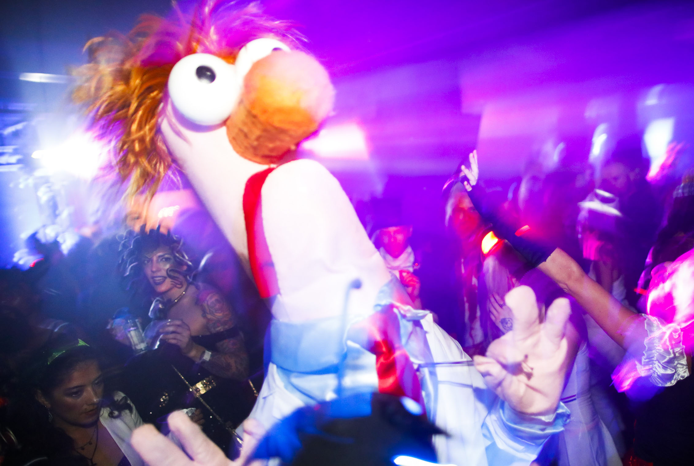 An reveler in a Beaker (from the Muppets) costume; image is a bit blurry and conveys a fun and chaotic party atmosphere