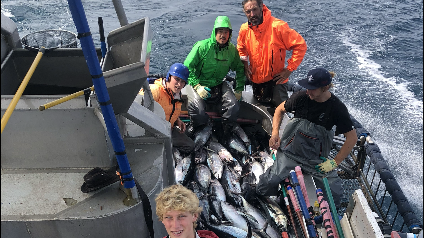 Scott Hawkins photographs his crew, including his sons Wyatt (left, blue helmet) and Colton (front, red jacket) with dozens of albacore tuna they caught in minutes.
