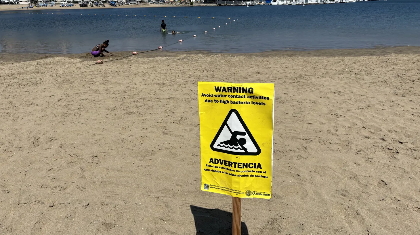 Kids splash around at Mother’s Beach, even with signs warning about playing in the water.