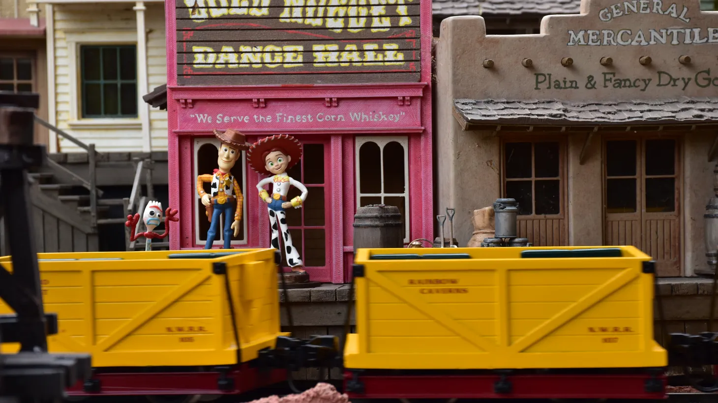 A model train moves past Woody and Jess from “Toy Story” in the section themed after Frontierland at Dave Sheegog’s backyard garden railroad in Anaheim.