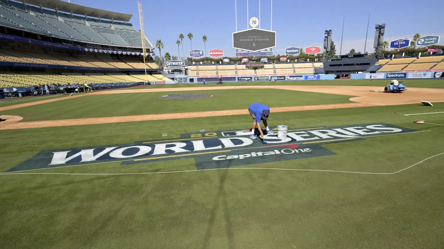 Workers paint the World Series logo on the field prior to team workouts at Dodgers Stadium, Oct 24, 2024.