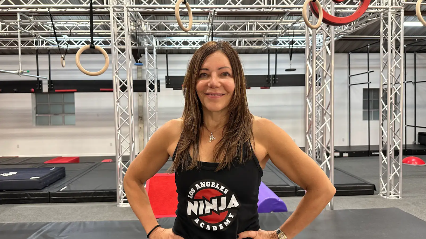 LA Ninja Academy founder Madelyn Scarpulla poses in front of obstacle course swings. She opened the Culver City gym this August.