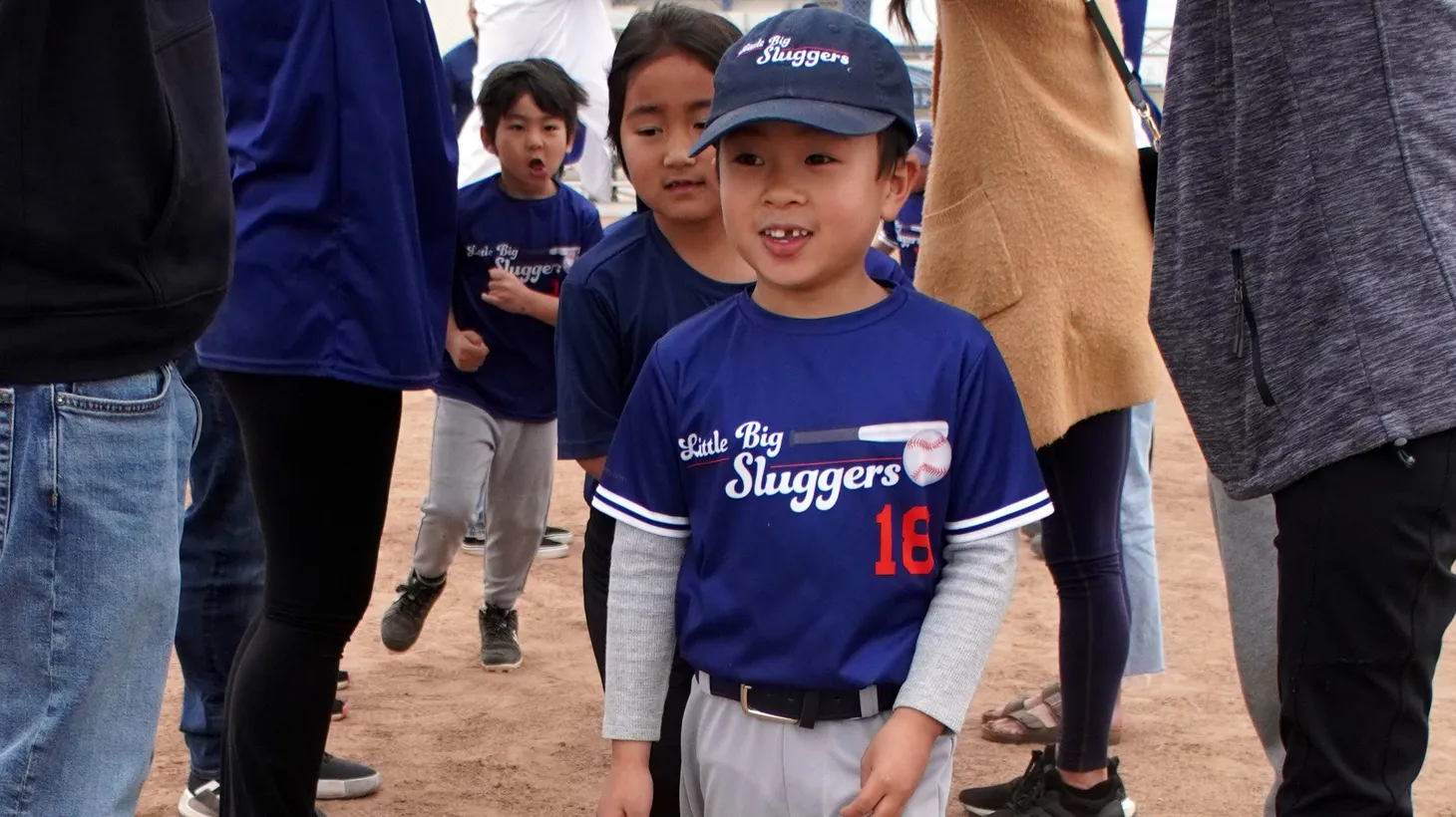 Eli Yano, a player on the Little Big Sluggers team, emerges from the tunnel of parents — a tradition at the end of T-ball games.