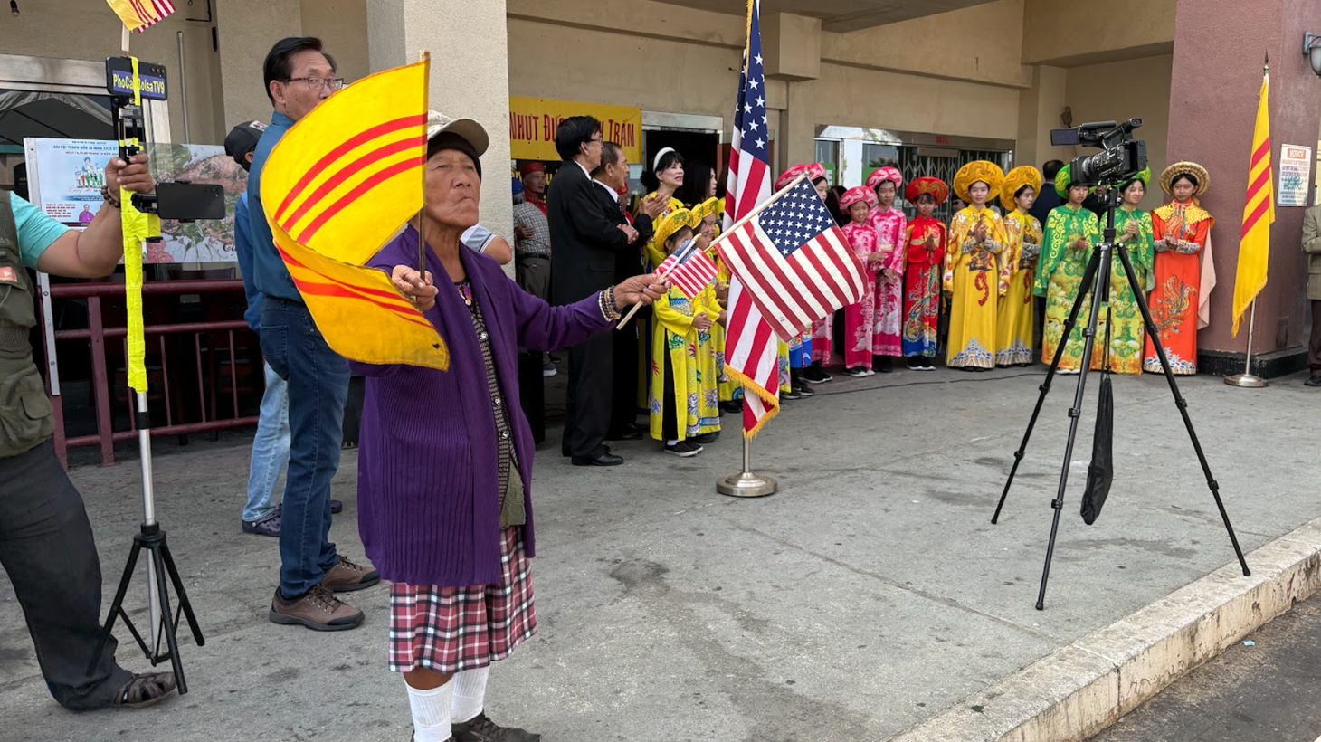 A woman waves the flags of America and the former Republic of Vietnam at a recent ceremony in Westminster.