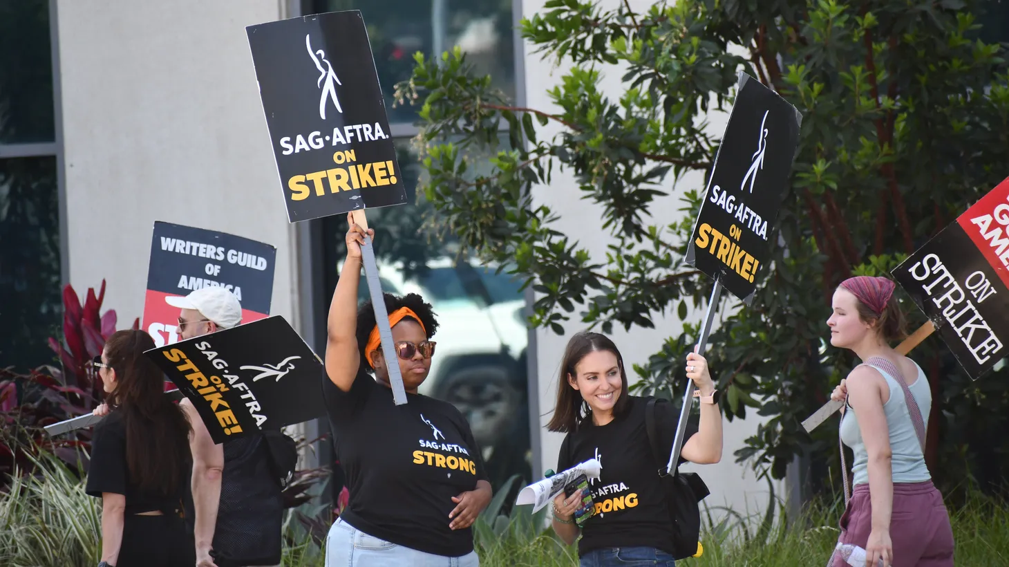 SAG-AFTRA members strike outside Netflix studios, July 27, 2023. As writers and actors fight for AI protections, studios are advertising AI jobs.