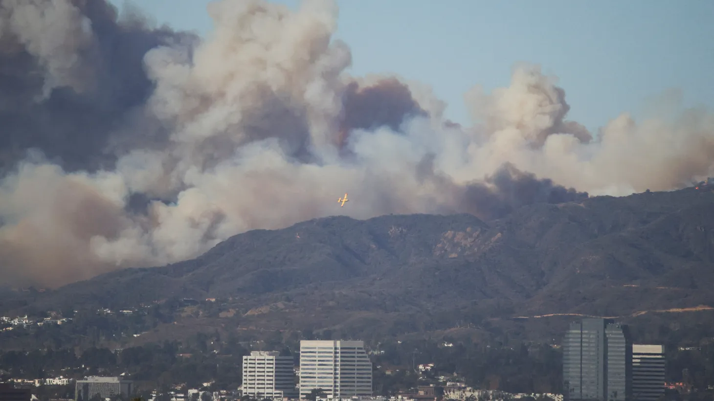 An aircraft flies to drop fire retardant over a wildfire burning near Pacific Palisades during a windstorm, in Los Angeles, California, January 7, 2025. REUTERS/Daniel Cole.