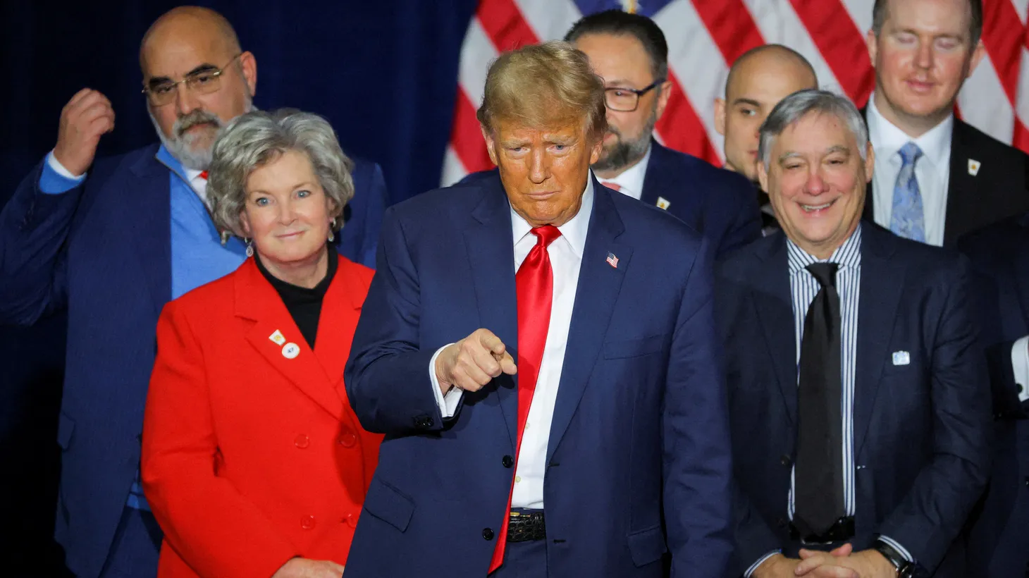 Republican presidential candidate and former U.S. President Donald Trump gestures as he stands with Chris LaCivita, Susie Wiles, Jason Miller, John Brabender, and other campaign officials during his caucus night watch party in Des Moines, Iowa, U.S., January 15, 2024.