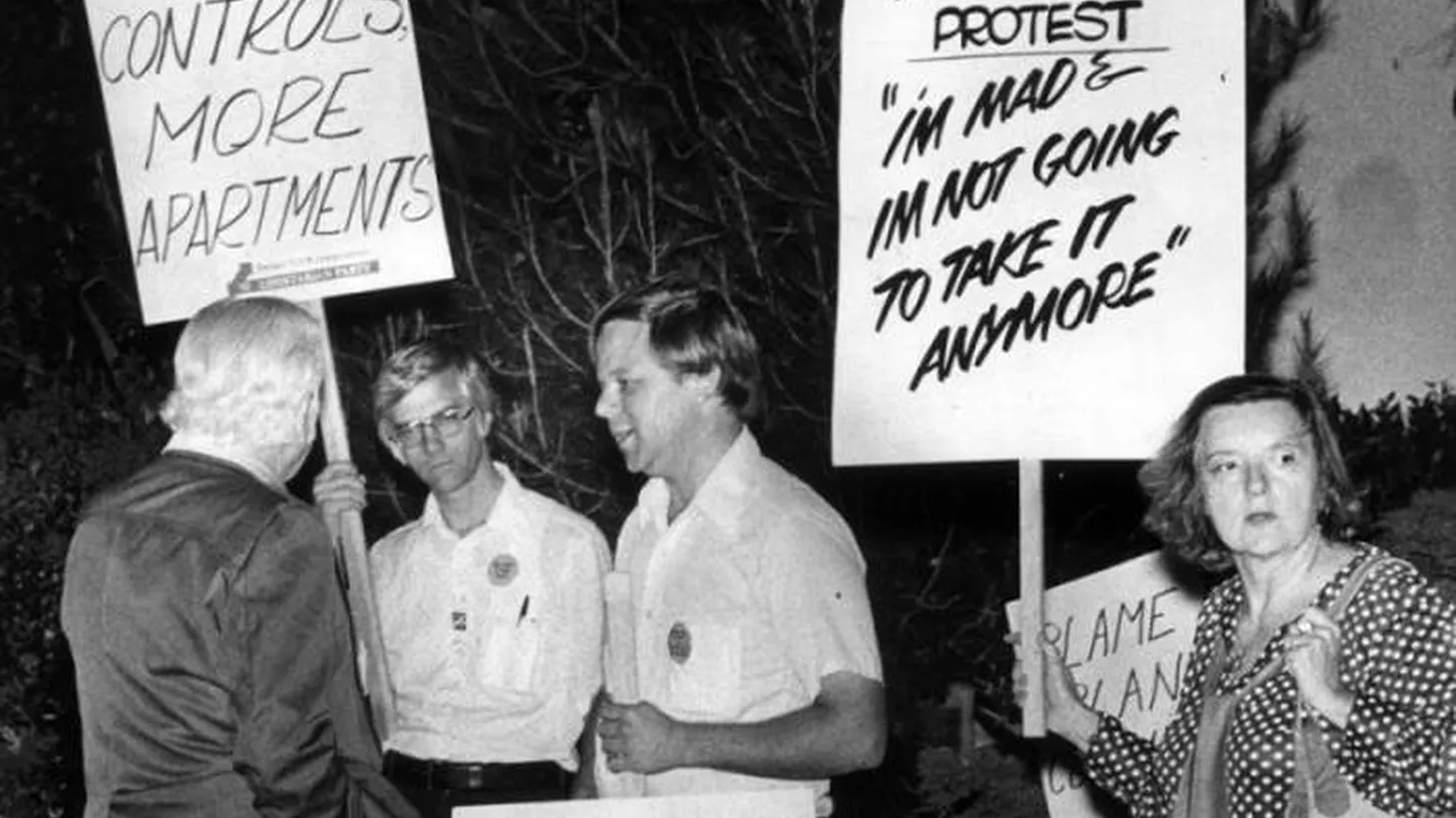 Libertarian Party members Ernest Glaberman and Ron Kellett, center, came to counter-picket the rent control rally held at the Santa Monica High School auditorium. They were not warmly welcomed by the crowd of over 250 in favor of rent control. Photograph dated September 27, 1977.