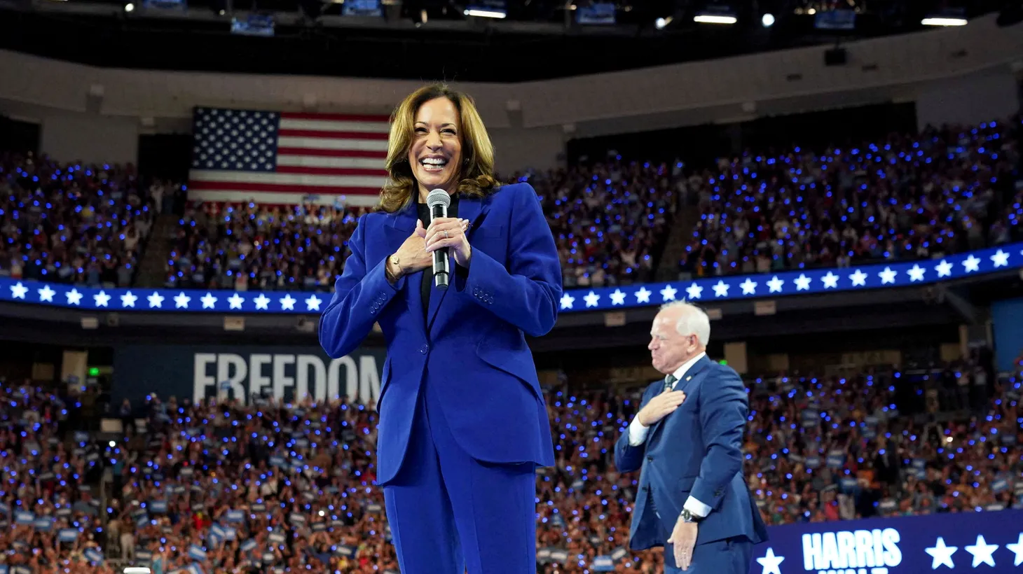 U.S. Vice President and Democratic presidential nominee Kamala Harris reacts, while her running mate Minnesota Governor Tim Walz stands nearby, as she is filmed for a broadcast into Chicago's Democratic National Convention (DNC), during her rally in Milwaukee, Wisconsin, U.S., August 20, 2024.