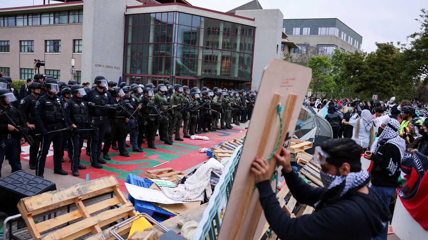 Demonstrators reinforce the barricade to the encampment as law enforcement officers arrive at the University of California, Irvine, after protesters against the war in Gaza surrounded the physical sciences lecture hall, as the conflict between Israel and Hamas continues, May 15, 2024.