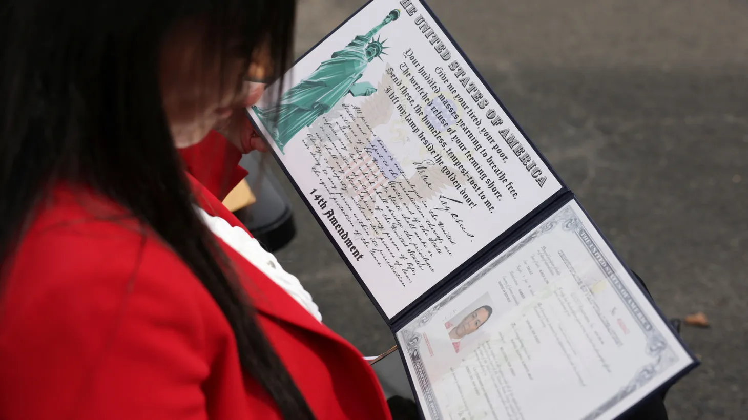 A new American citizen reads her certificate at the naturalization ceremony at Liberty State Park in Jersey City, New Jersey, U.S., September 17, 2024.